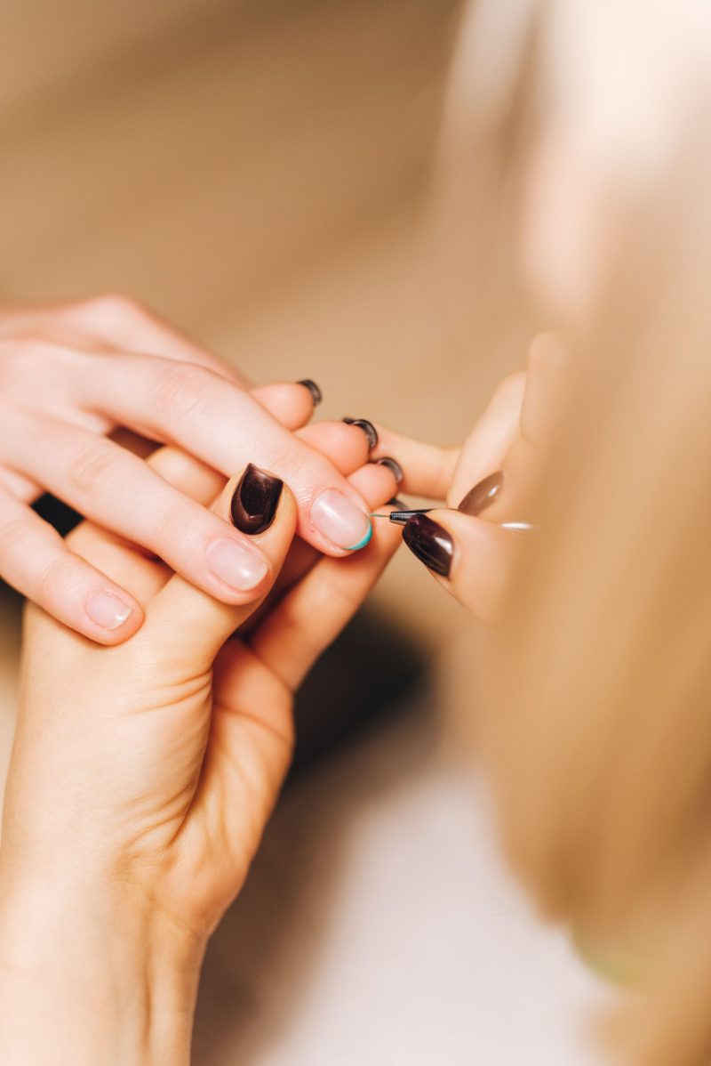 Manicure fazendo as unhas de uma cliente